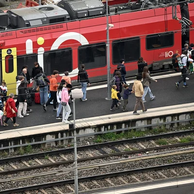 Train régional à quai avec des passagers et des bagages sur le quai