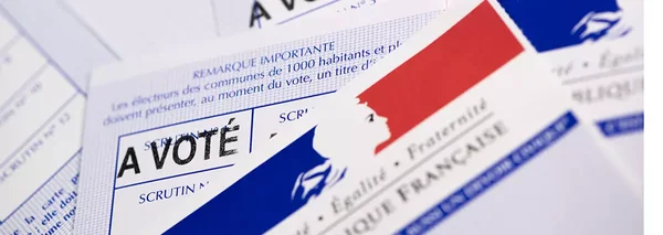 Gros plan d'une main remplissant un bulletin de vote