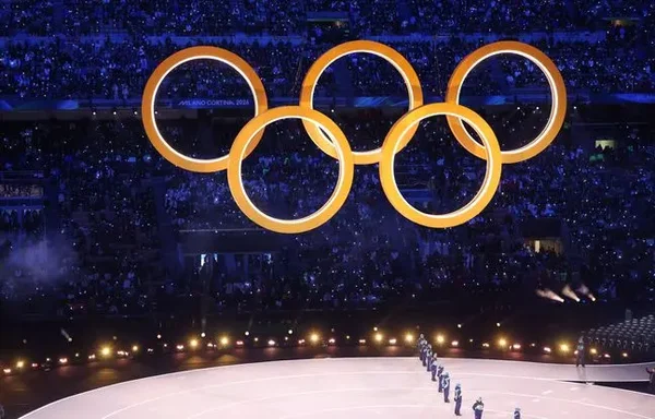 Les cinq anneaux olympiques illuminés au-dessus de la foule à la fin des Jeux de Milan-Cortina.