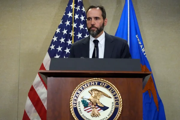 Jack Smith s'exprimant à un podium portant le sceau du ministère de la Justice.