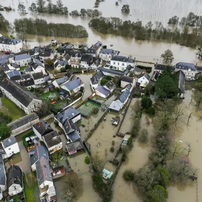 Vue aérienne impressionnante d'un village submergé par les eaux de crue.