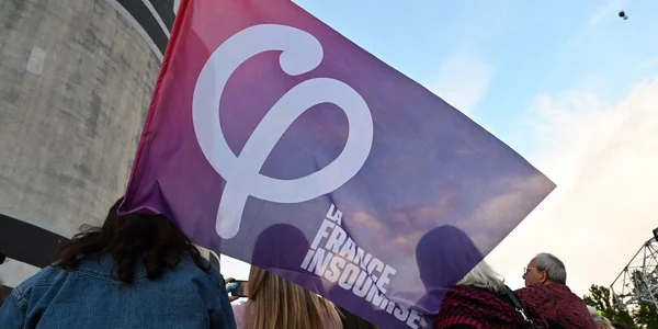 Le drapeau du parti La France Insoumise brandi lors d'un événement politique.