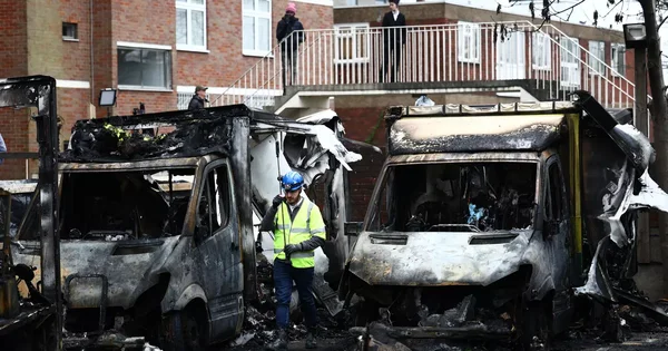 Des véhicules calcinés devant un immeuble à Liège après les explosions revendiquées par le groupe islamiste pro-iranien HAYI.