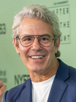 Andy Cohen souriant à la caméra.