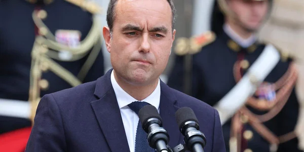 Sébastien Lecornu prenant la parole devant un podium, encadré par des gardes en uniforme.