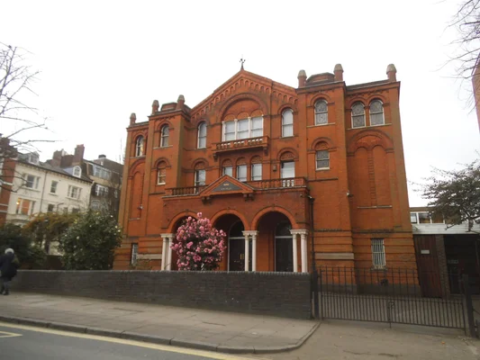 La Nouvelle Synagogue de Stamford Hill à Hackney, un édifice en briques rouges au milieu d'une zone résidentielle.