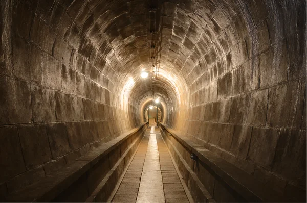 Tunnel dans le Fort de Mutzig, avec ses murs de pierre et son passage central.