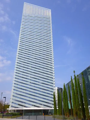 L'entrée du bâtiment abritant le siège d'Estée Lauder Companies à Londres, avec panneau d'identification et piétons circulant devant.
