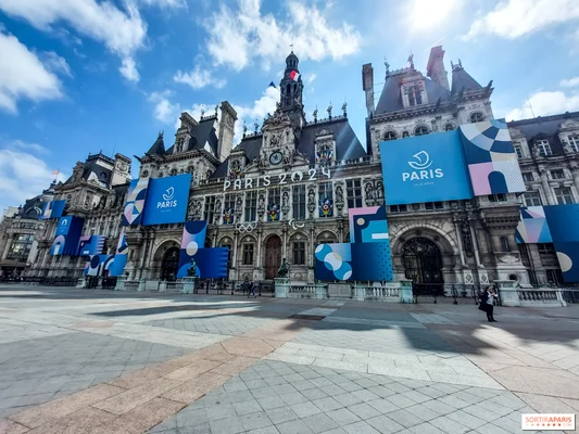 L'Hôtel de Ville de Paris pavoisé de bannières Paris 2024 au premier plan de la place.