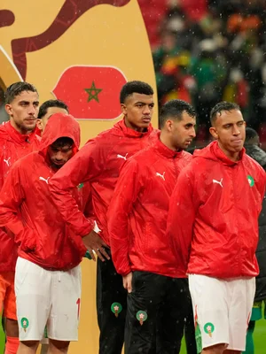 L'équipe du Maroc alignée sur le terrain sous la pluie lors de la compétition.