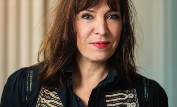 Portrait de Jil Caplan portant une chemise sombre brodée.
