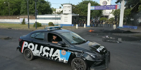 Véhicule de la Policia Santa Fe devant le siège de la police avec un feu sur la chaussée.