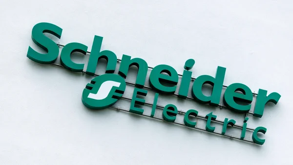 Le logo tridimensionnel vert de Schneider Electric apposé sur un mur, arborant l'emblème circulaire caractéristique avec le 'S' stylisé.