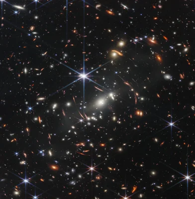 Image télescopique d'un amas de galaxies avec une étoile centrale aux diffractions lumineuses.