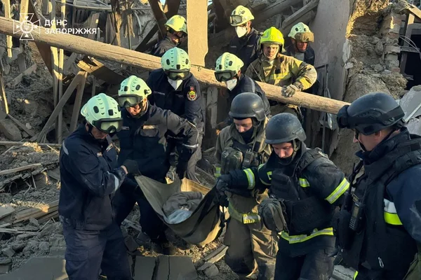 Des secouristes évacuent une victime dans les décombres d'une zone sinistrée après une attaque.