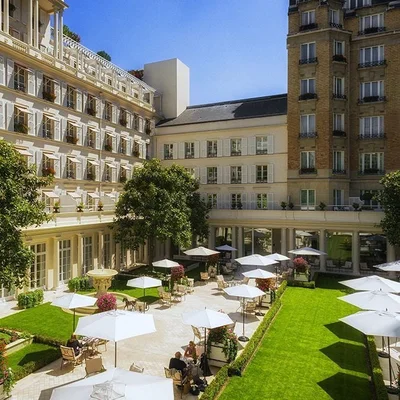 La cour du palace Le Bristol Paris aménagée avec parapluies et pelouses.