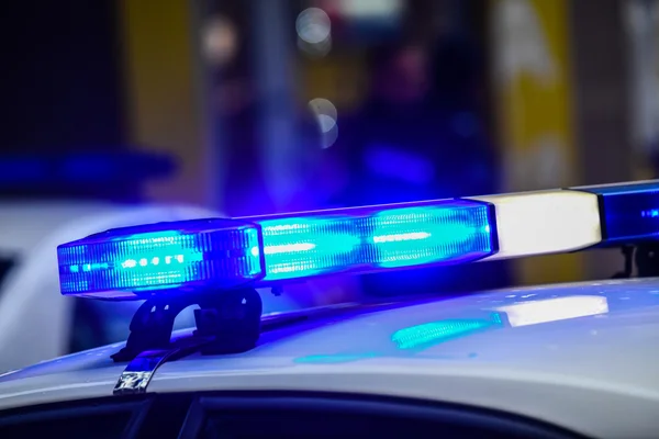 Gyrophare bleu de police scintillant dans la nuit parisienne lors de l'opération sécuritaire.