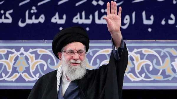 Une photographie de l'Ayatollah Ali Khamenei levant la main.