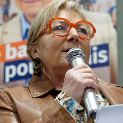 Natacha Bouchart, lunettes rouges et veste en cuir, s'exprimant au micro.