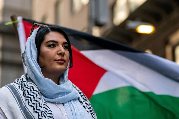 Nerdeen Kiswani lors d'une manifestation, entourée de drapeaux palestiniens aux couleurs rouge, noir, blanc et vert.