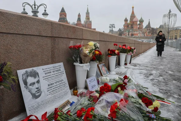 Le mémorial improvisé avec fleurs et photos sur le pont Nemtsov, avec les tours du Kremlin en arrière-plan enneigé.