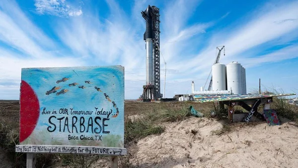Installations de SpaceX à Boca Chica avec un panneau Starbase et une fusée visible sur le pas de tir.
