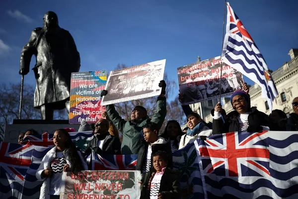 Manifestation pour les îles Chagos avec drapeaux et panneaux dénonçant l'injustice historique.