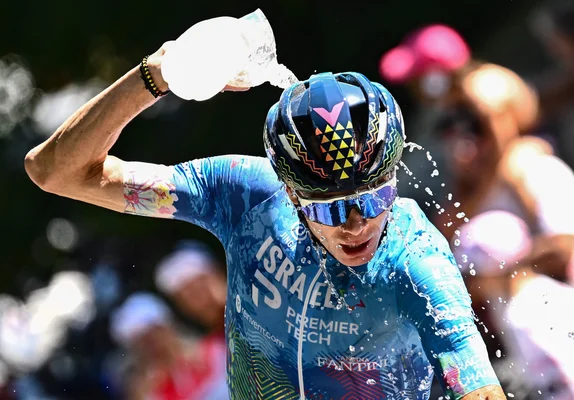 Un coureur d'Israel Premier Tech se verse de l'eau sur la tête pendant le Tour de France pour lutter contre la chaleur.