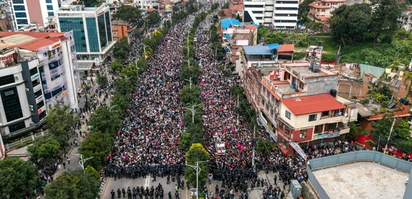 Manifestation de masse au Népal avec des milliers de personnes et une ligne de police anti-émeute.