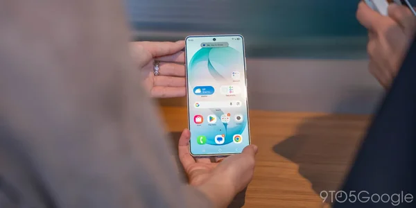 Une main tenant un smartphone avec une interface météo visible.