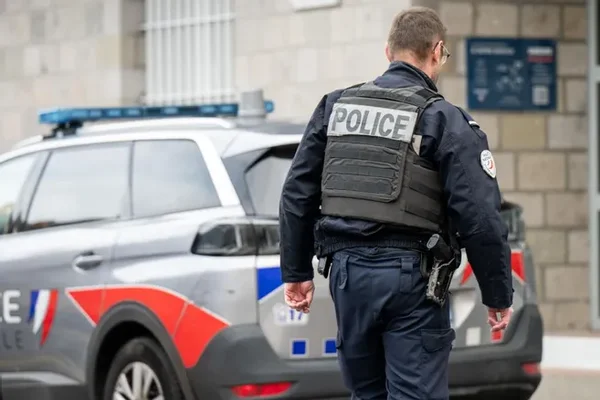 Un officier examinant un engin suspect devant une banque parisienne lors de l'attentat déjoué.