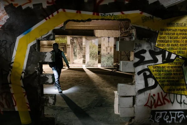 Tunnel graffitié menant vers l'extérieur de La Défense, traversé par un visiteur des Extatiques.