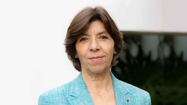 Le Palais de l'Élysée illuminé au crépuscule, avec sa cour intérieure et son drapeau national.