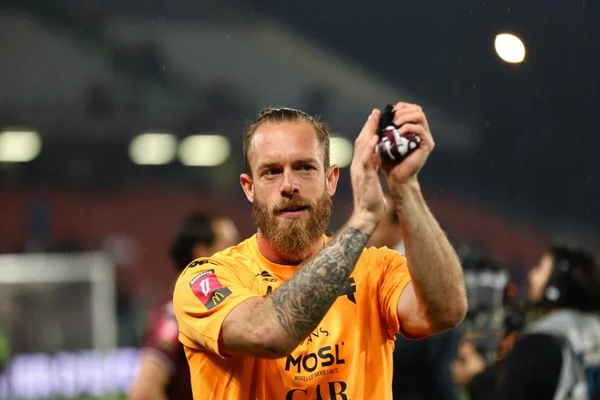 Alexandre Oukidja pose avec le maillot du FC Metz dans les tribunes du stade.