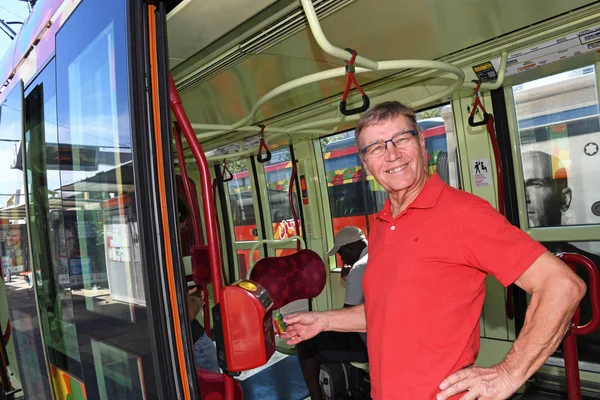 Un passager tenant sa carte de transport à l'intérieur du véhicule.