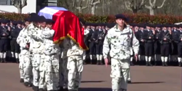 Le corps du soldat porté par un détachement en tenue hivernale.