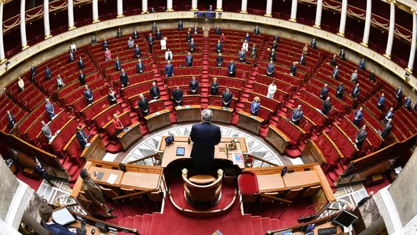 Vue en plongée de l'hémicycle de l'Assemblée nationale avec des députés en costume assis respectant la distanciation sociale, lors du déconfinement.