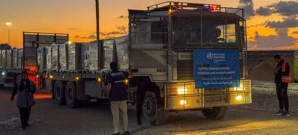 Un camion de l'OMS transportant des fournitures médicales au coucher du soleil.