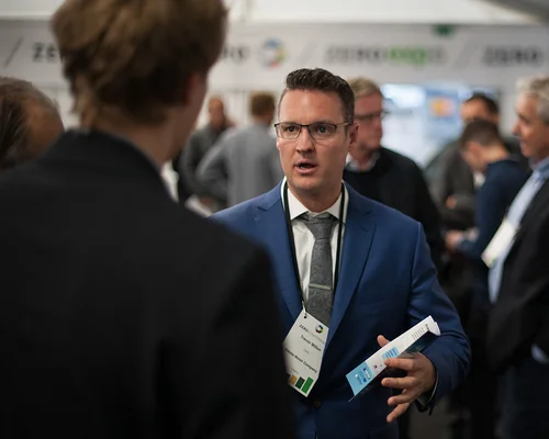 Trevor Milton conversant avec un participant lors d'un événement professionnel.