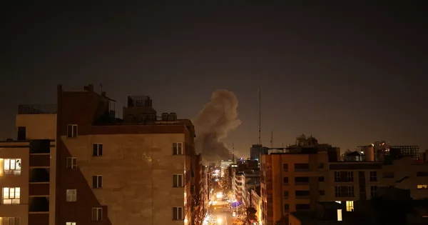 Une scène urbaine de nuit illuminée avec un panache de fumée s'élevant au loin