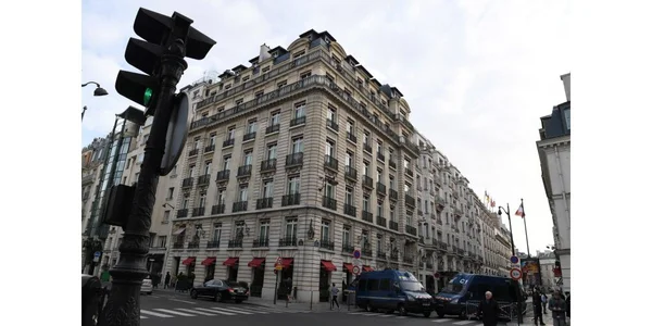La façade de l'hôtel Bristol et ses balcons caractéristiques à Paris, sous un ciel couvert.