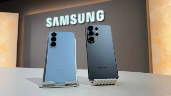 Les modèles bleu clair et gris foncé de la série Galaxy S26 posés sur des supports, exposant leurs modules photo.