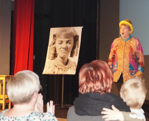 Alison Arngrim présentant La Malle aux trésors, tenant une photo noir et blanc.
