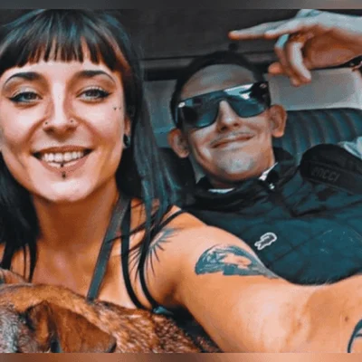 Un couple tenant des photographies posées sur une table dans une pièce en pierre.