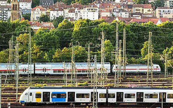 Deux trains circulant sur des voies ferrées près d'une ville.