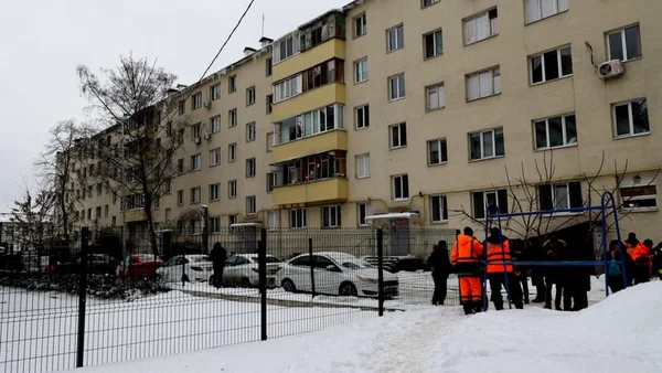 Vue d'un immeuble résidentiel enneigé avec des secouristes sur le lieu d'une attaque en Russie.
