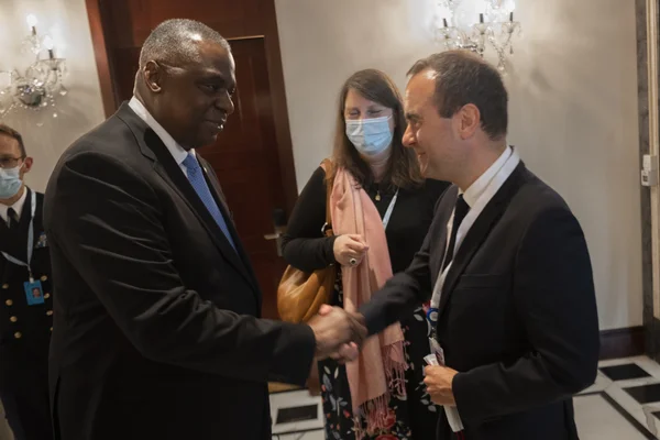 Sébastien Lecornu et Lloyd J. Austin III échangeant une poignée de main lors du Shangri-La Dialogue à Singapour en juin 2022.