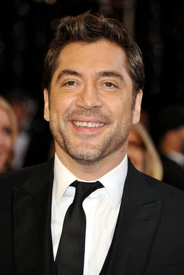 Javier Bardem souriant en costume noir et cravate noire lors d'un événement, photographié sur IMDb.