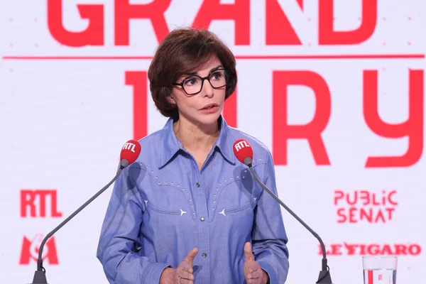 Un passant observant les affiches électorales d'Emmanuel Grégoire et de Rachida Dati à Paris