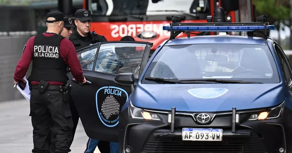 Agents de la PFA et chien reniflant l'herbe dans un parc lors des recherches.